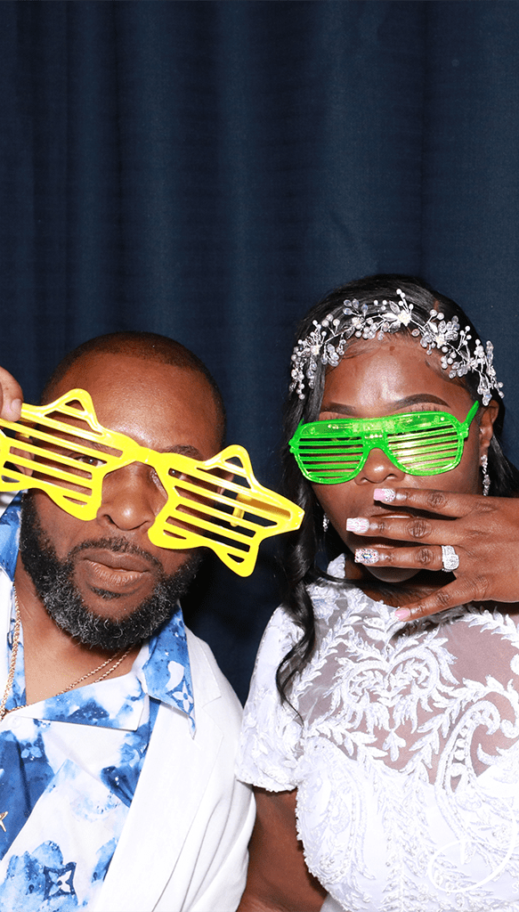 This is a photo of a bride and groom taking a photo with Dat Le Studios's photo booth